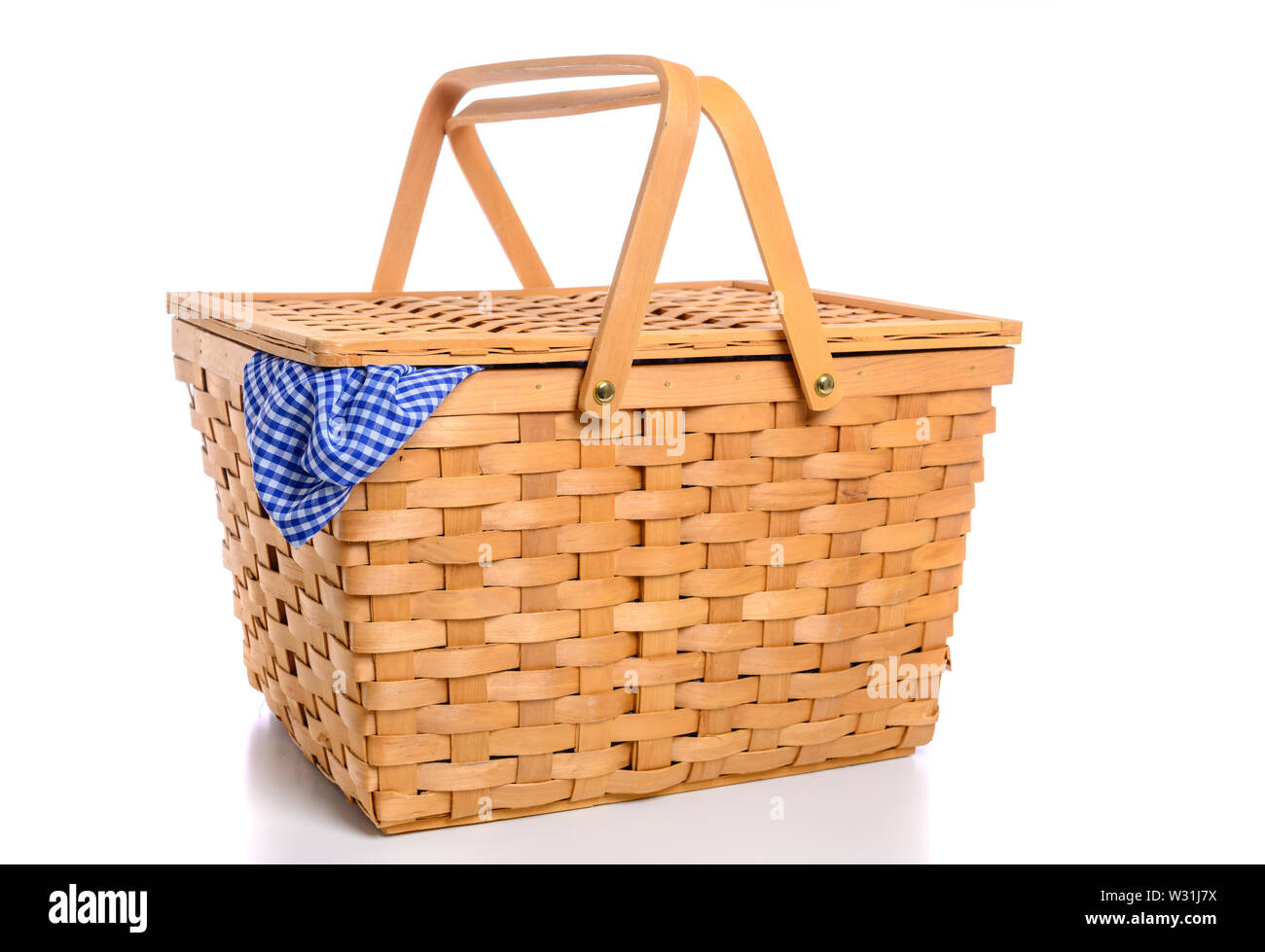 A brown wicker picnic basket on a white background with gingham cloth ...