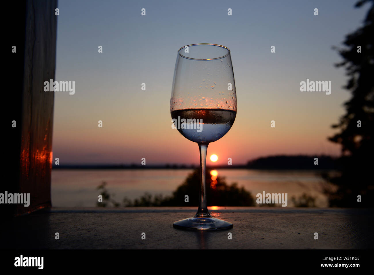 Wine glass at sunset.  Barnes Island, Maine.  Off of Harpswell Neck.  Penobscot Bay.  Atlantic Ocean. Stock Photo