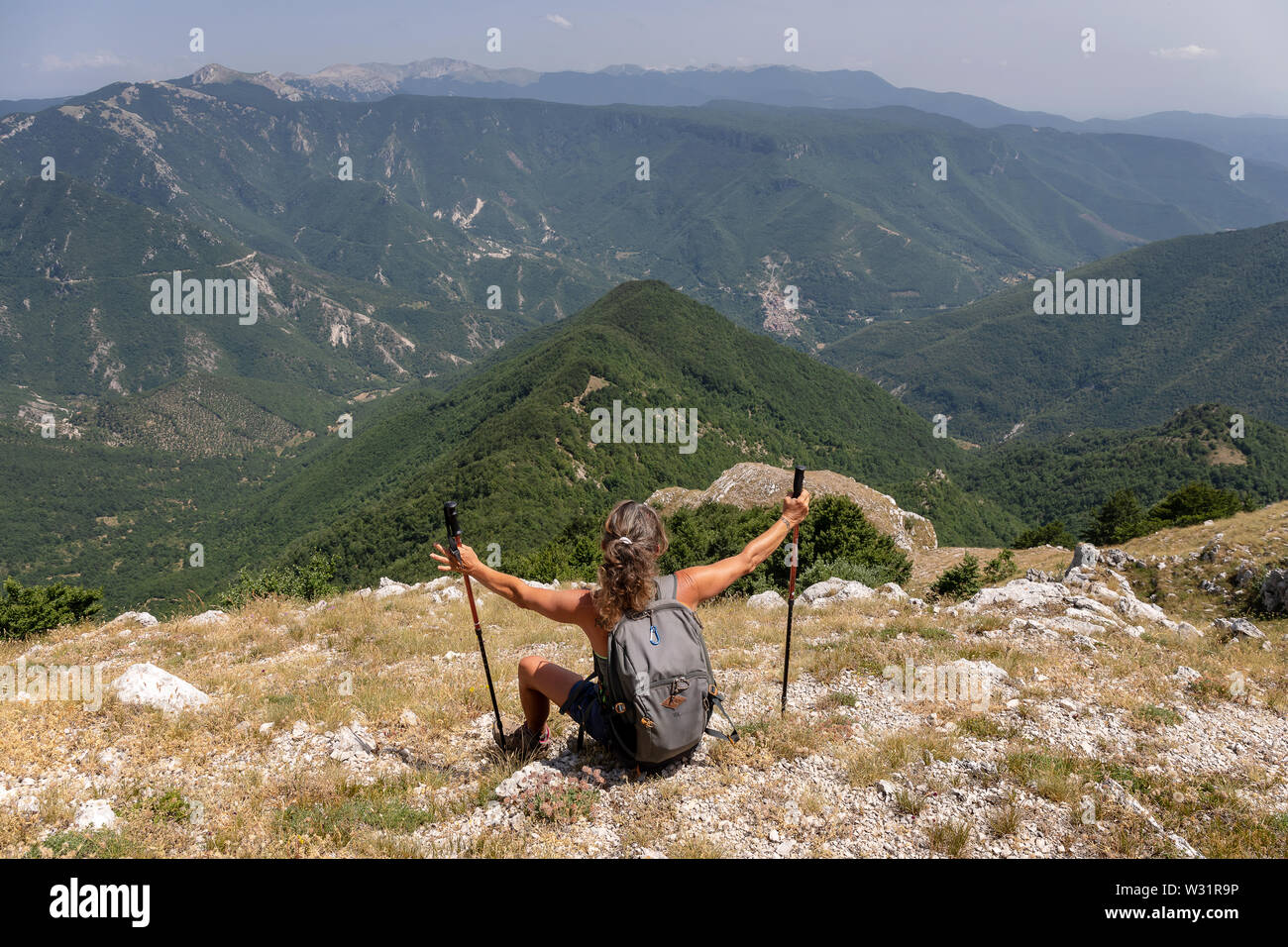 Subiaco RM, Italy - 07 July 2019: woman hiker admires the landscape on the horizon, from the top of the mountain. Stock Photo