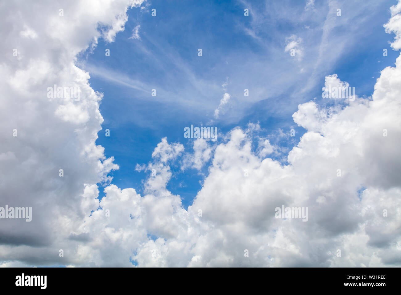 Big white clouds surrounding an area of blue sky Stock Photo - Alamy