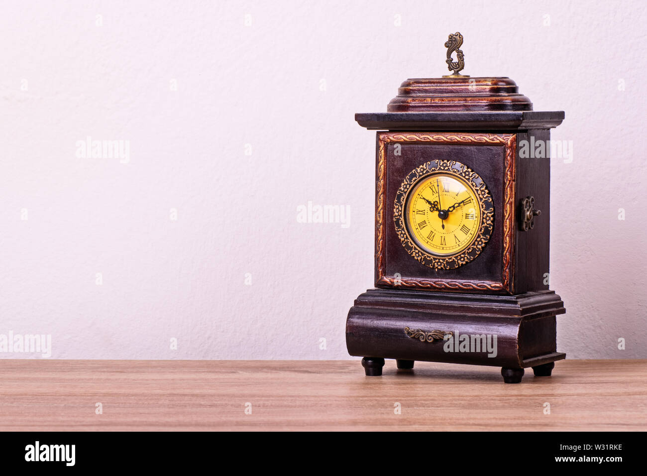 Antique Victorian clock on a wooden table. Stock Photo