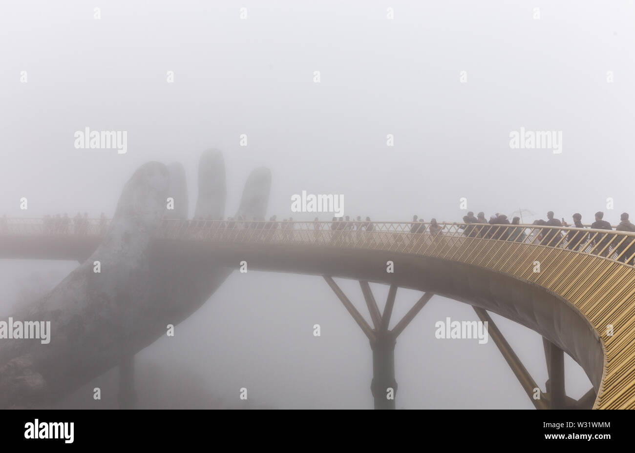 Danang , Vietnam - JANUARY 04, 2019 : View in Fog of the Golden Bridge on Ba Na Hills in Da Nang Stock Photo
