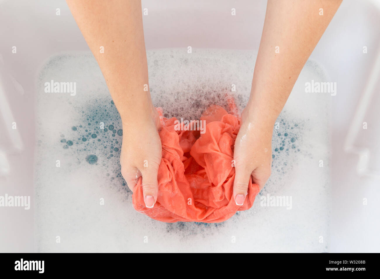 Female Hands Washing Clothes In Sink In Laundry Room Stock