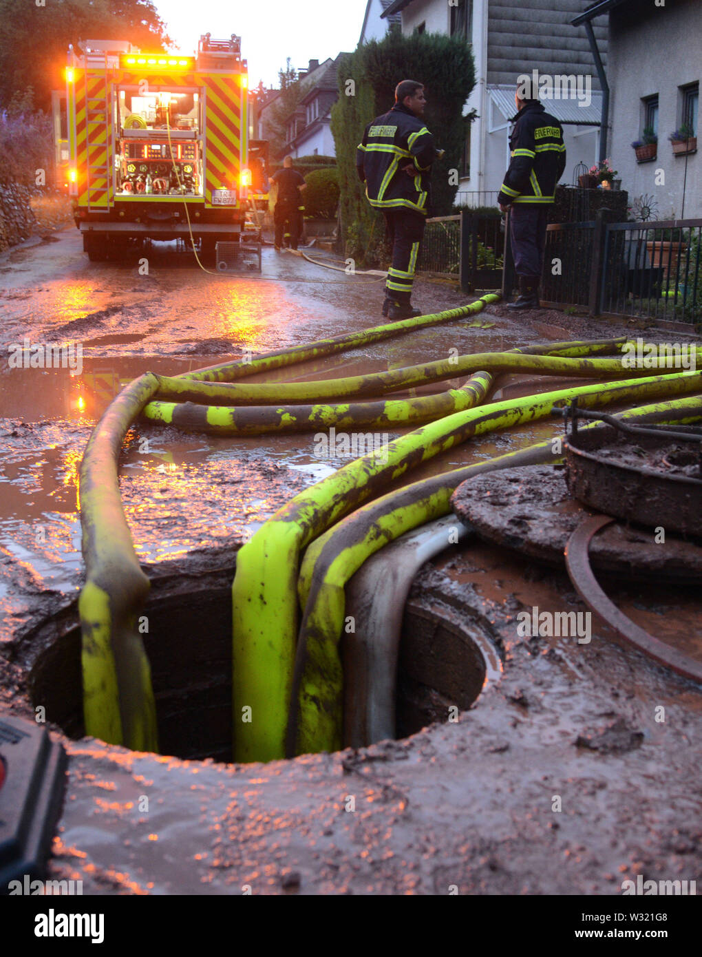 Trier, Germany. 11th July, 2019. Firefighters pump a cellar in the Olewig district empty. A violent storm with heavy rain and hail swept over the region and flooded numerous streets and cellars. Credit: Harald Tittel/dpa/Alamy Live News Stock Photo