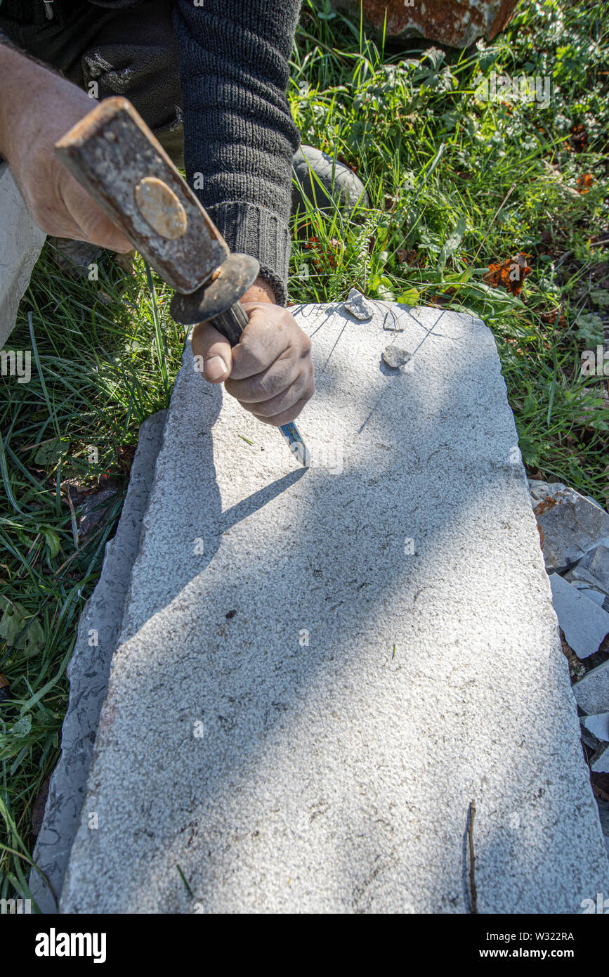 Top view of an artist carving in stone using mallet and a chisel Stock