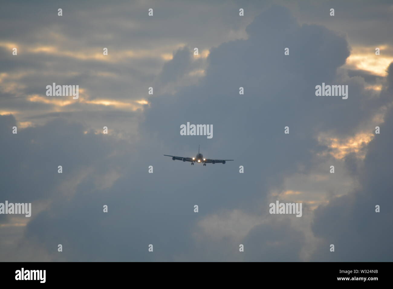 KC 135 aircraft on landing approach against a pastel coloured evening cloud bank Stock Photo
