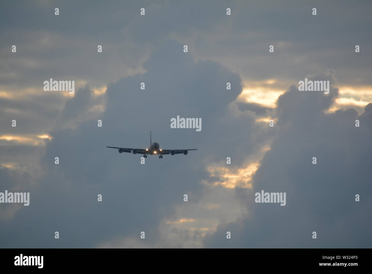 KC 135 aircraft on landing approach against a pastel coloured evening cloud bank Stock Photo