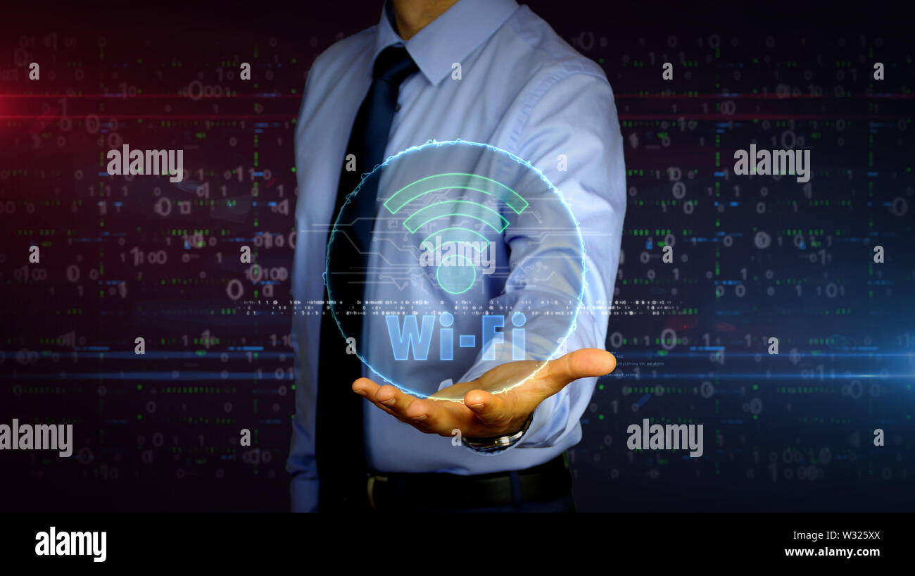 Man with wi-fi symbol hologram on hand. Businessman showing futuristic concept of wireless communication, mobile connection and hot spot with glitch e Stock Photo