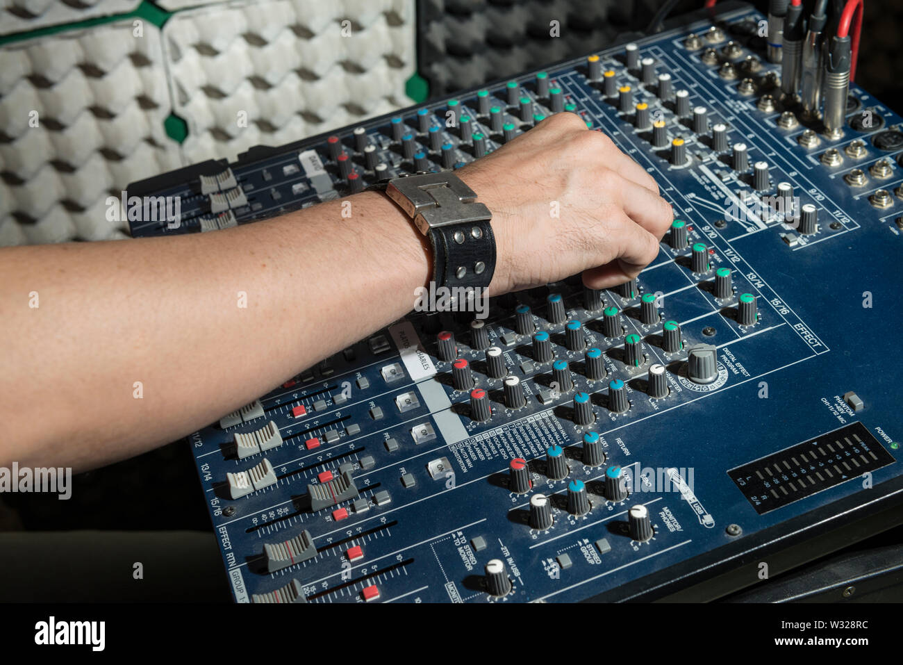 Music concept. Detail of the hands of a man manipulating a mixing desk