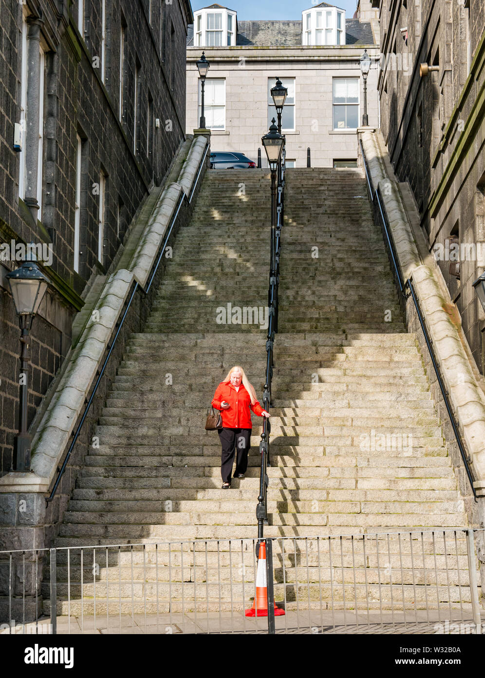 Woman walking down steep steps between Crown terrace and Bridge Street, Aberdeen City, Scotland, UK Stock Photo