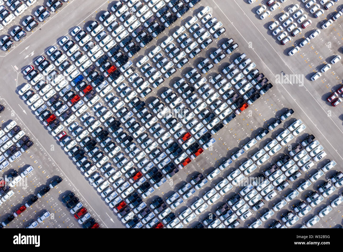 Aerial top view new cars lined up in the port for import export business logistic and transportation by ship in the open sea. New cars from the car fa Stock Photo