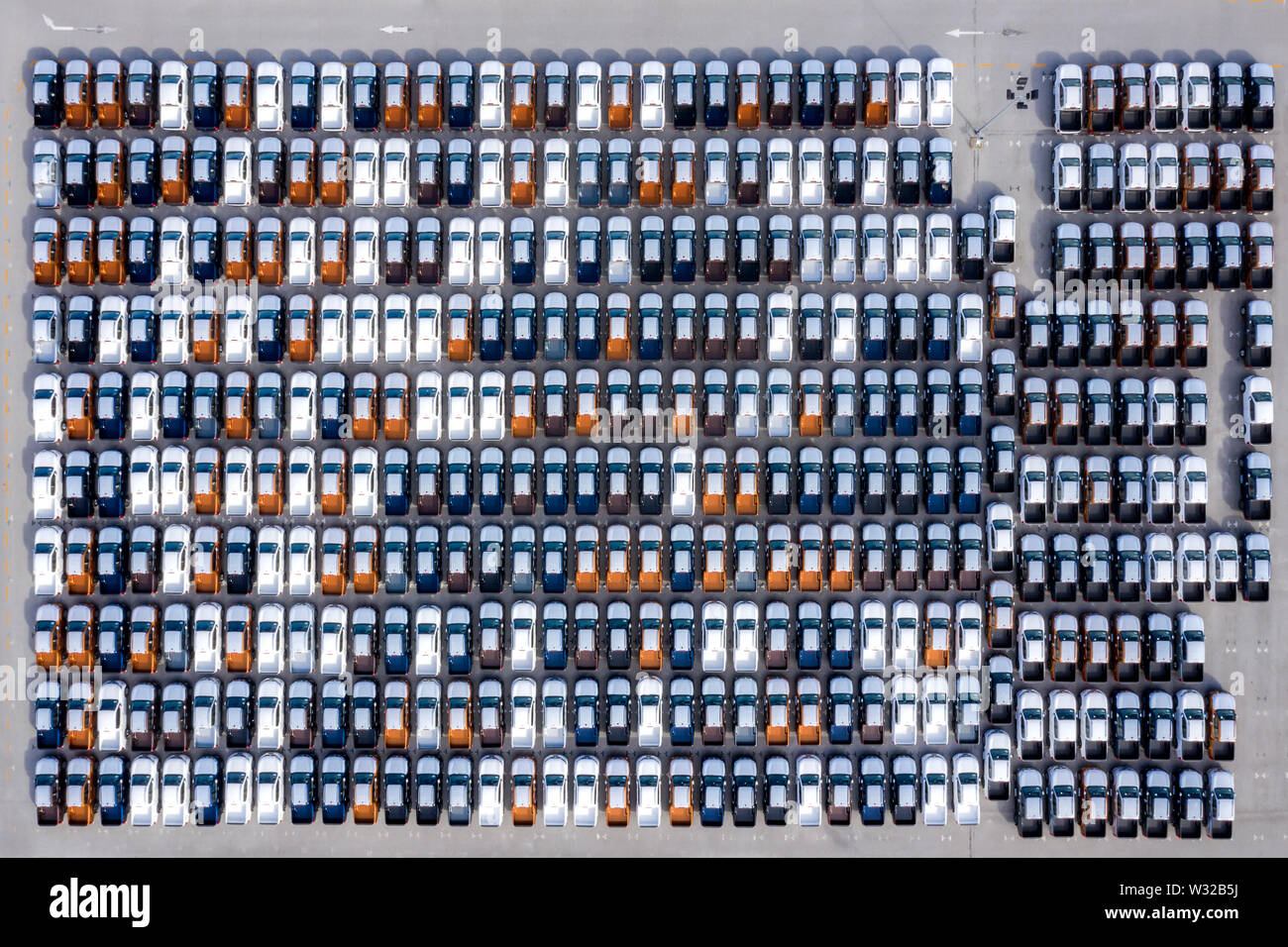 Aerial top view new cars lined up in the port for import export business logistic and transportation by ship in the open sea. New cars from the car fa Stock Photo