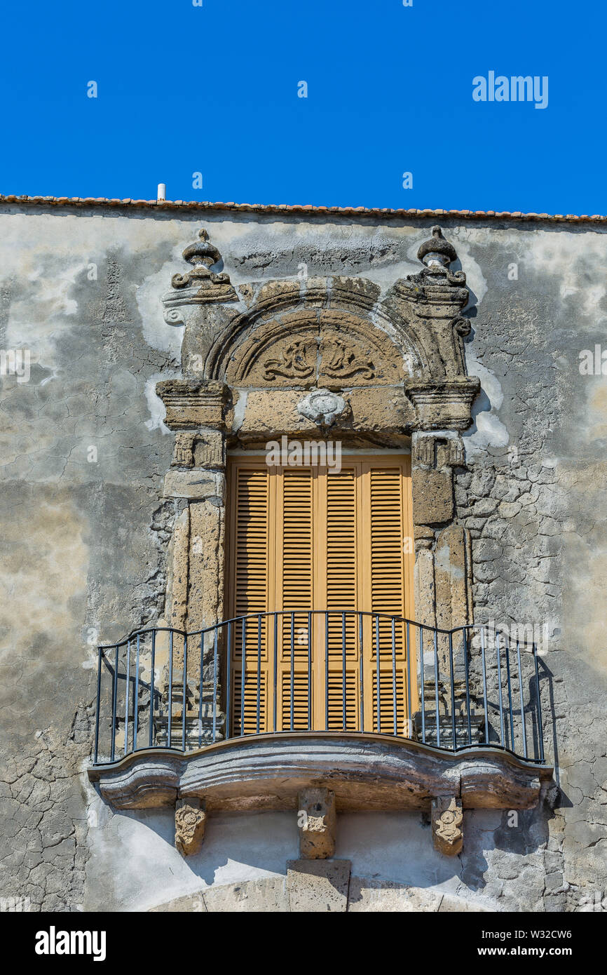 baroque mediterranean balcony with closed wooden shutters, a iron railing on a weathered stone wall Stock Photo