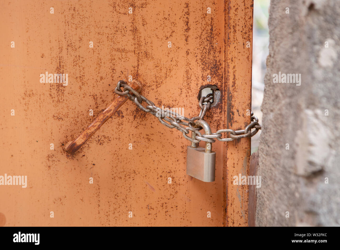 barricaded rusty door with door lock and chain Stock Photo