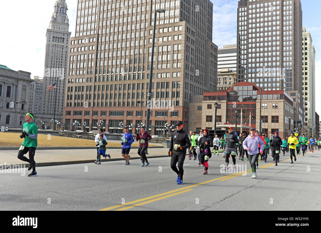 Runners make their way down St. Clair Avenue in downtown Cleveland, Ohio, USA during the 2019 St. Patrick's Day Run. Stock Photo