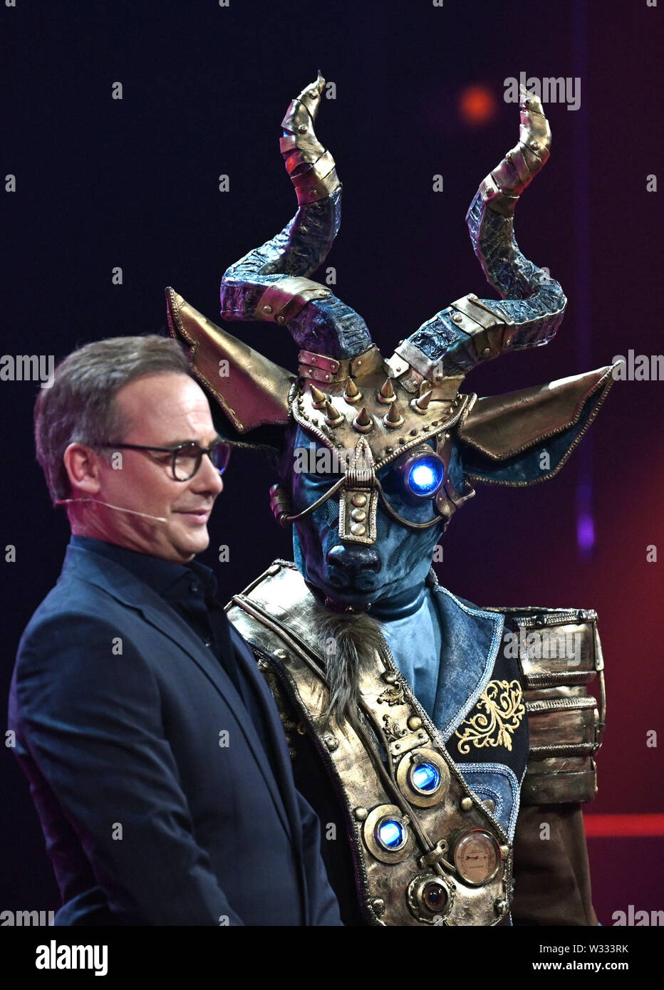 Cologne, Germany. 11th July, 2019. The presenter Matthias Opdenhövel (l)  and the Kudu (r) are on stage at the ProSieben show "The Masked Singer".  Credit: Henning Kaiser/dpa/Alamy Live News Stock Photo -