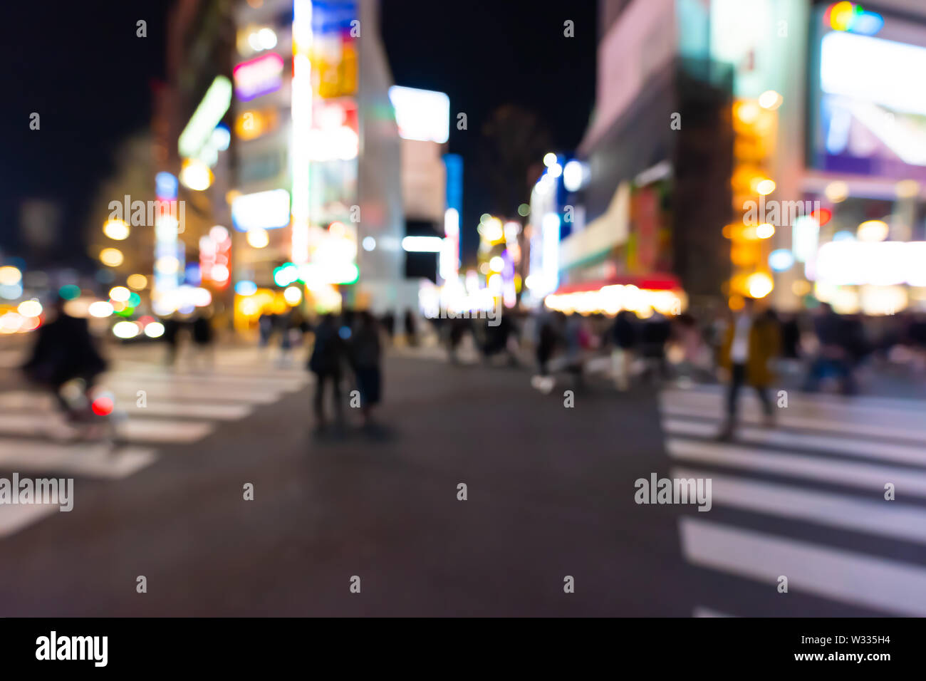 Defocused blurred background of people crossing crosswalk at Kabukicho red light district in Shinjuku, Tokyo Japan at dark night, nightlife Stock Photo