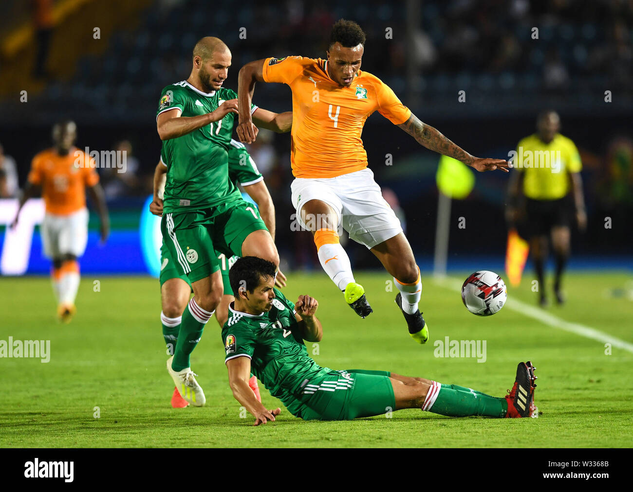Suez. 11th July, 2019. Jean-Pphilippe Gbamin (up) of Cote d'Ivoire skips Aissa Mandi of Algeria's tackle during the quarterfinal match between Cote d'Ivoire and Algeria at the 2019 Africa Cup of Nations in Suez, Egypt on July 11, 2019. The match ended 1-1 through extra time. Algeria beat Cote d'Ivoire 4-3 in a penalty shootout. Credit: Li Yan/Xinhua/Alamy Live News Stock Photo
