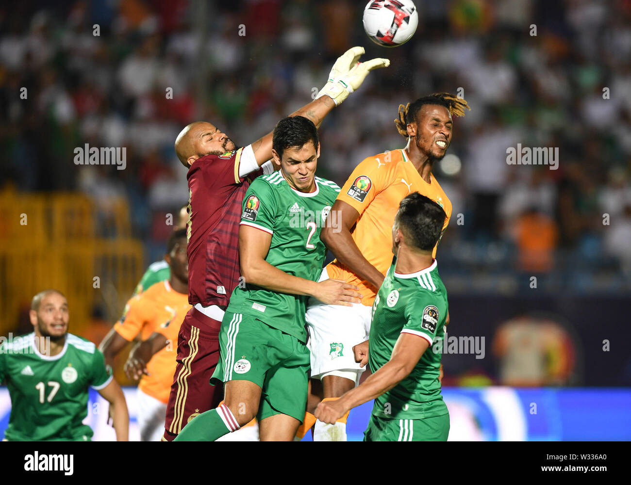 Suez. 11th July, 2019. Adi-Rais Cobos Mbolhi (1st L) of Algeria blocks a shot during the quarterfinal match between Cote d'Ivoire and Algeria at the 2019 Africa Cup of Nations in Suez, Egypt on July 11, 2019. The match ended 1-1 through extra time. Algeria beat Cote d'Ivoire 4-3 in a penalty shootout. Credit: Li Yan/Xinhua/Alamy Live News Stock Photo