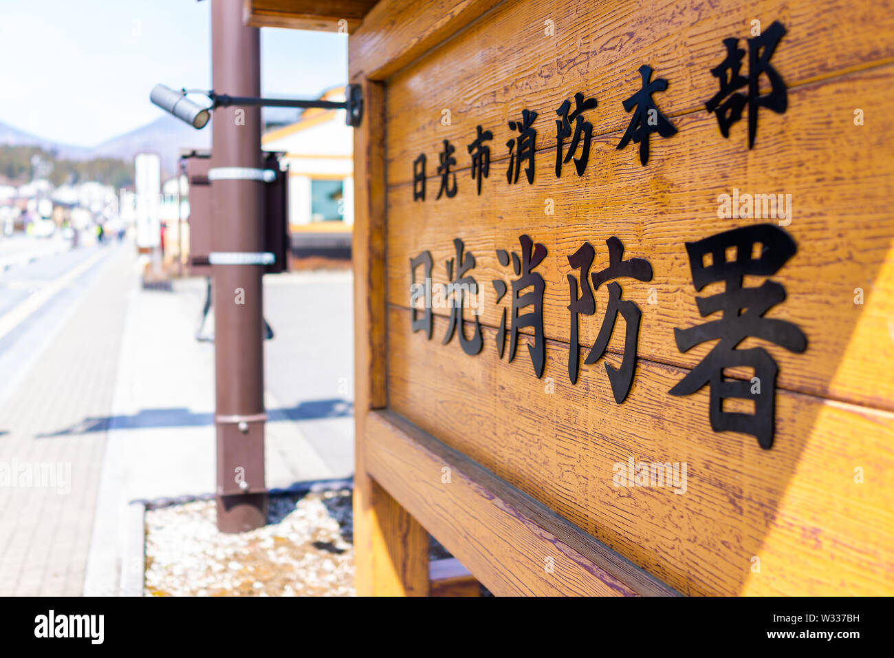 Nikko, Japan - April 4, 2019: Wooden board on street of mountain village with text saying Nikko City Fire Department sign Stock Photo