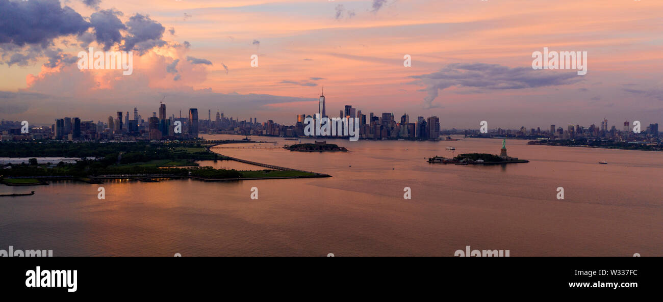 Three cities can be seen in this view of Hudson Bay at dusk with the Statue of Liberty Visible Stock Photo