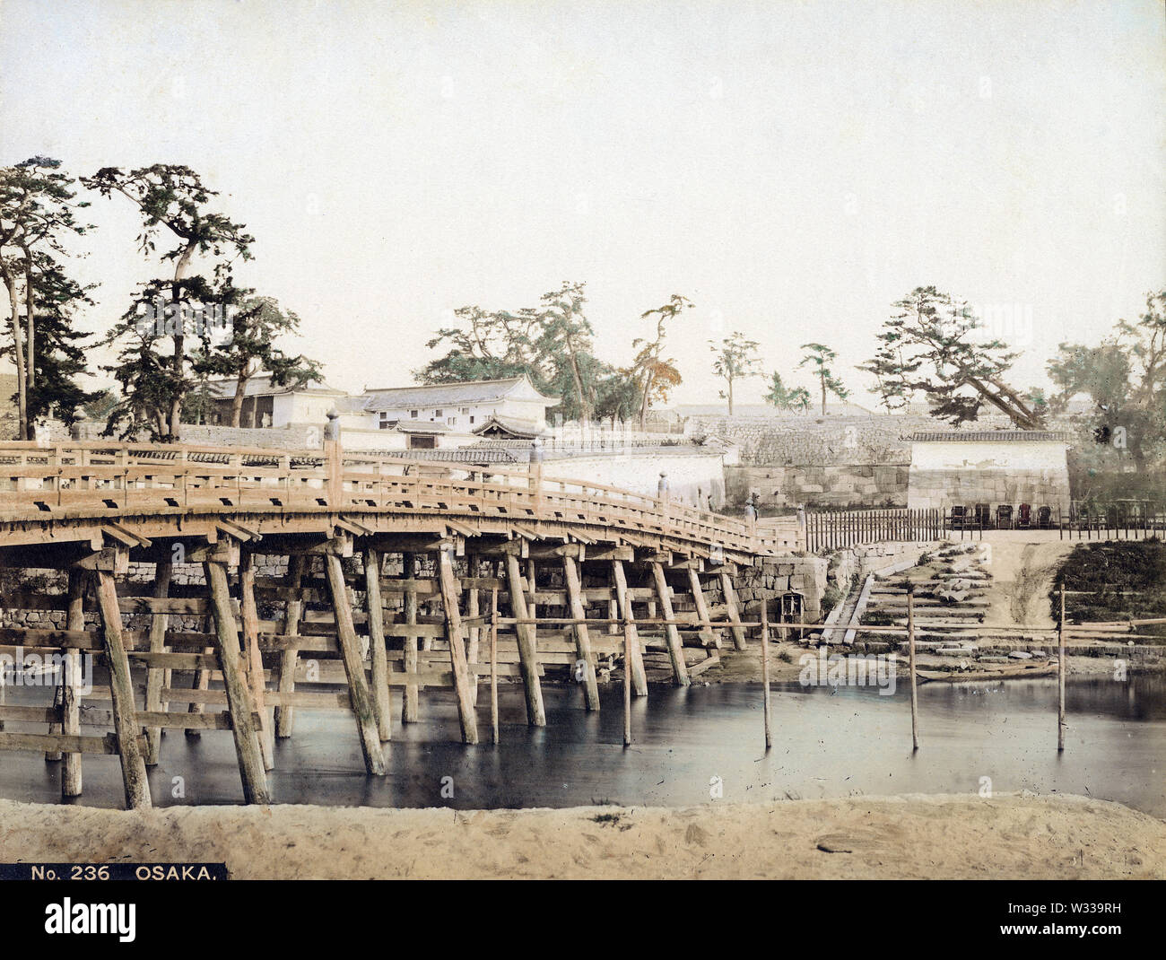 [ 1860s Japan - Kyobashi Bridge at Osaka Castle ] —   An extremely rare view of the wooden Kyobashi Bridge crossing the Neyagawa River (寝屋川) at Osaka Castle, Osaka, ca. 1860s (early Meiji). The bridge, first erected in 1623, was named Kyobashi because the road it connected to lead to Kyoto (京街道, Kyokaido).  In 1885 (Meiji 18) the bridge was washed away during a flood and replaced with an iron construction.  19th century vintage albumen photograph. Stock Photo