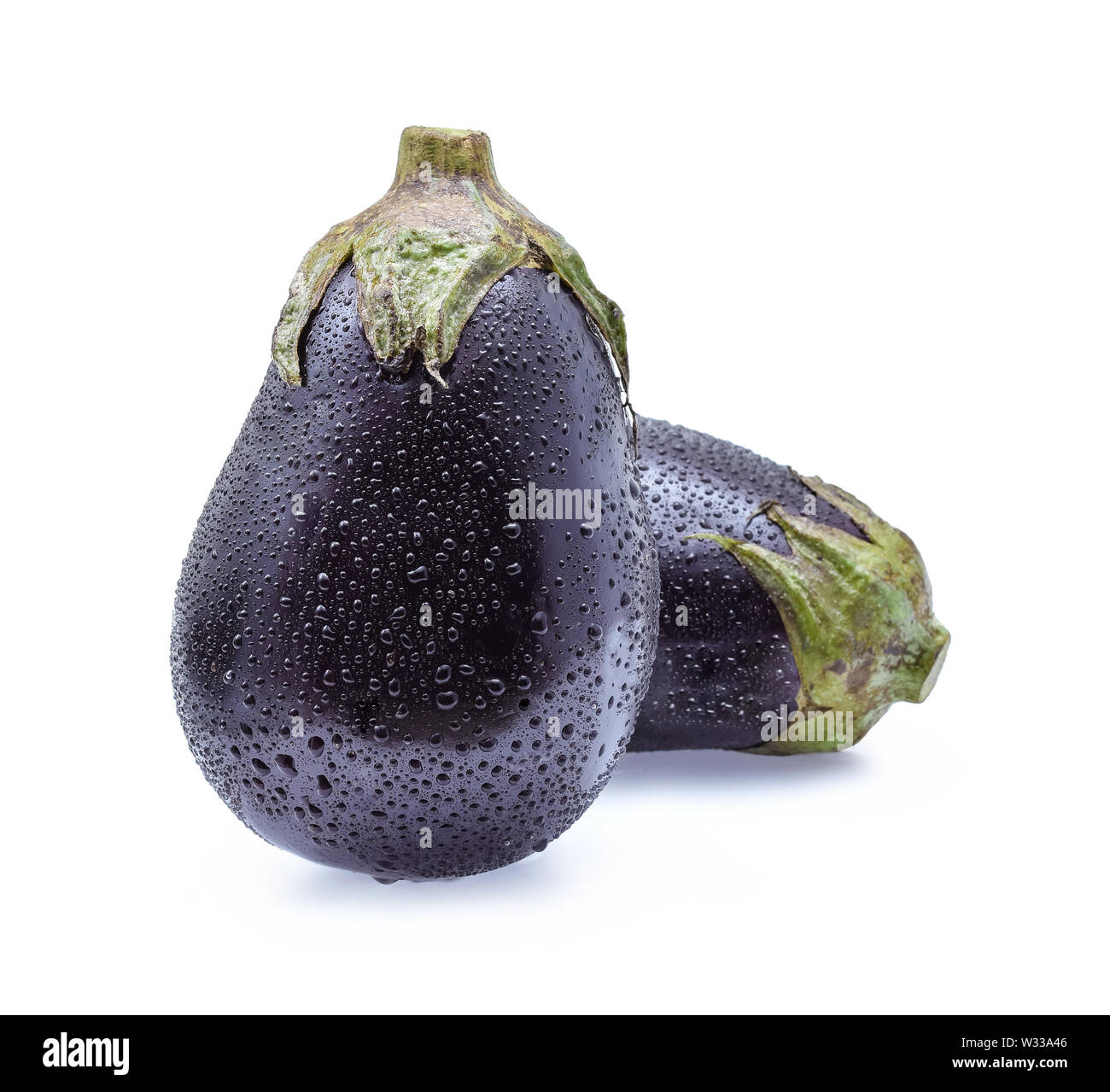 Raw eggplants with water drops on white background. Stock Photo