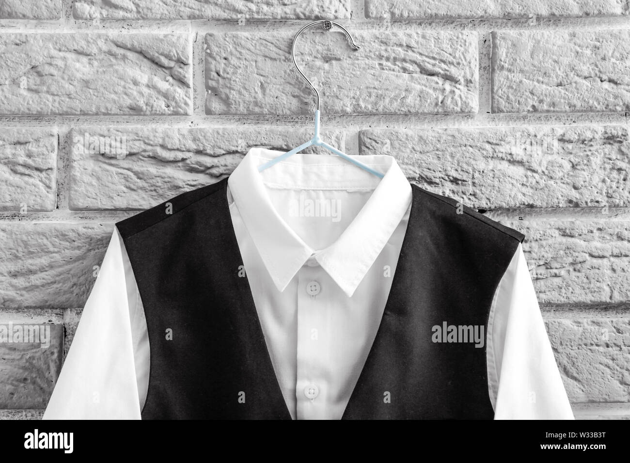 Stylish school uniform hanging on brick wall Stock Photo - Alamy