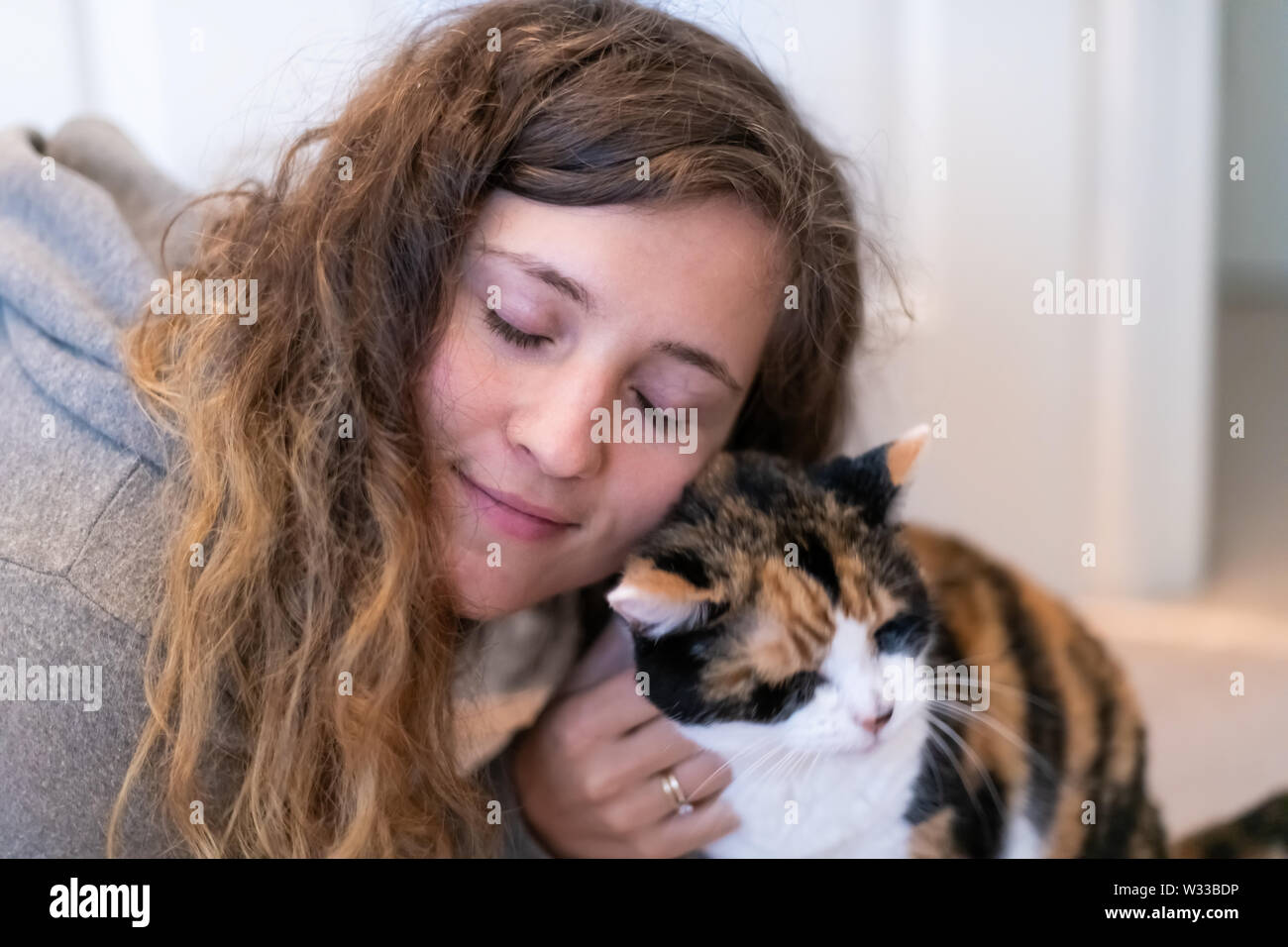Closeup Portrait Of Happy Smiling Young Woman Bonding With Calico