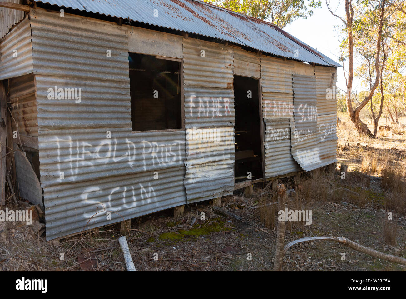 old derelict house outside Emmaville in northern new south wales, australia, with graffiti complaining about child abuse by an unknown old priest Stock Photo