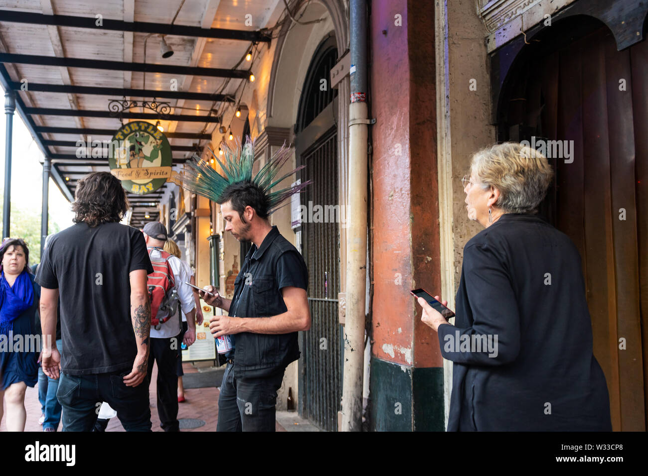 New Orleans, USA - April 22, 2018: People walking on Decatur street sidewalk in French quarter by restaurants and Turtle bay food and spirits bar in e Stock Photo