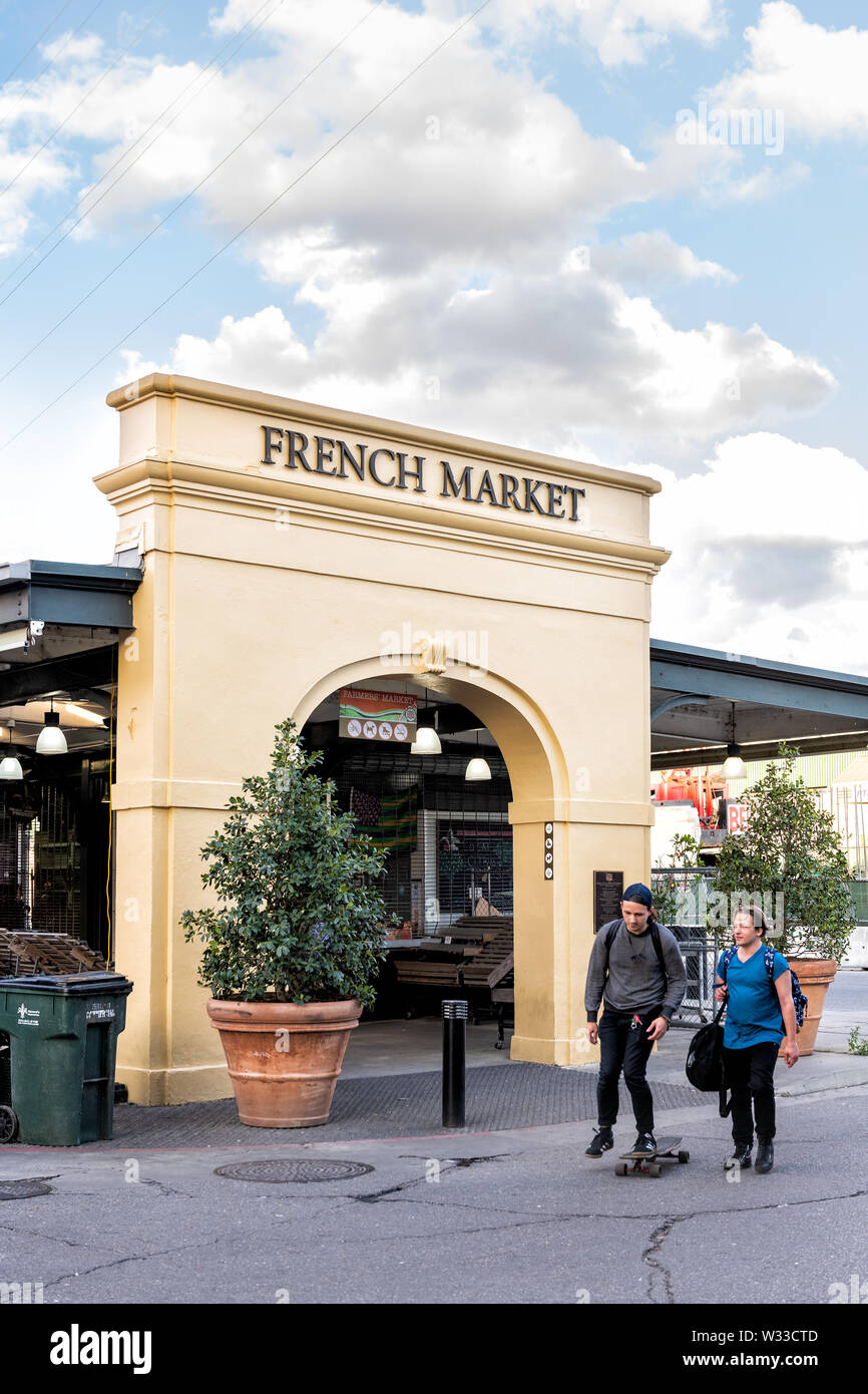 New Orleans, USA - April 22, 2018: French market sign and entrance in city quarter with many stores and restaurants and people walking on street in su Stock Photo