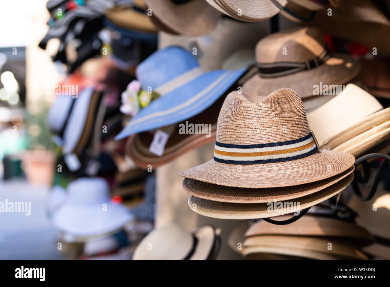 Stack stacked fedora man straw hats on retail display of street vendor store with many colors in New Orleans, Louisiana Stock Photo