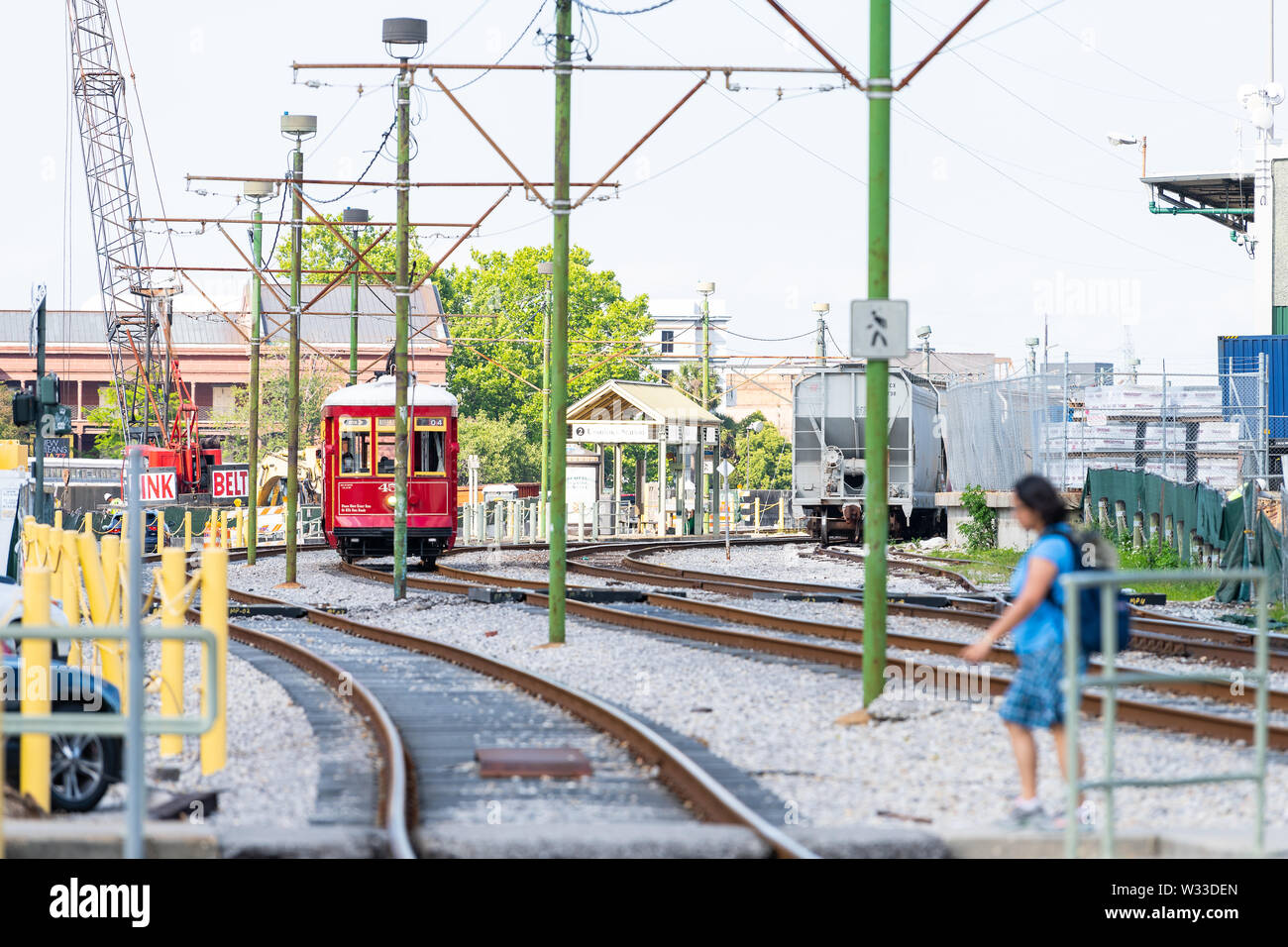 New Orleans, USA - April 23, 2018: Old town street in Louisiana famous city tram streetcar railroad tracks on Dumaine street station stop people walki Stock Photo