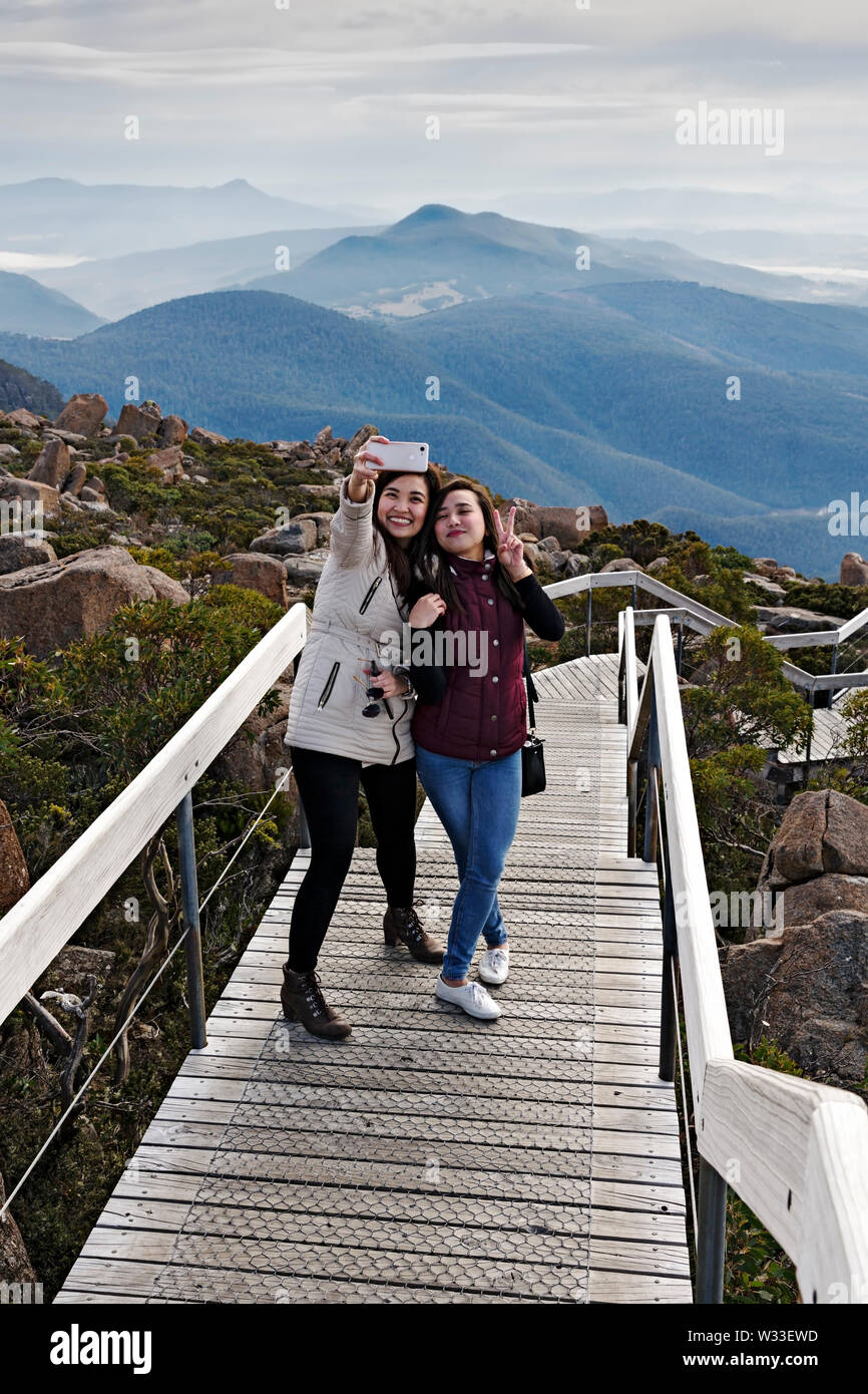 Hobart Australia / A couple of tourists enjoy taking selfies from the summit of Mount Wellington. Stock Photo