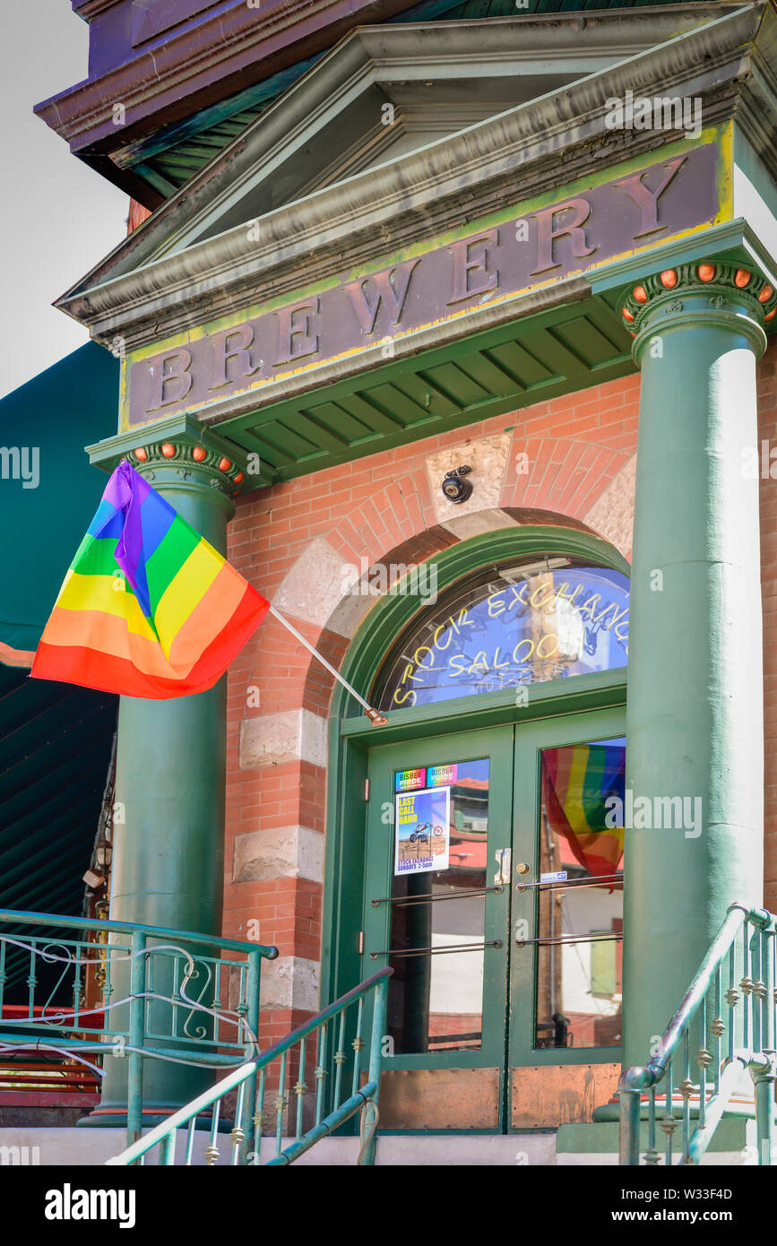 The stately Stock Exchange Saloon and Grill building entrance, once held a brokerage firm, flies a Rainbow Flag in the old mining town of Bisbee, AZ, Stock Photo