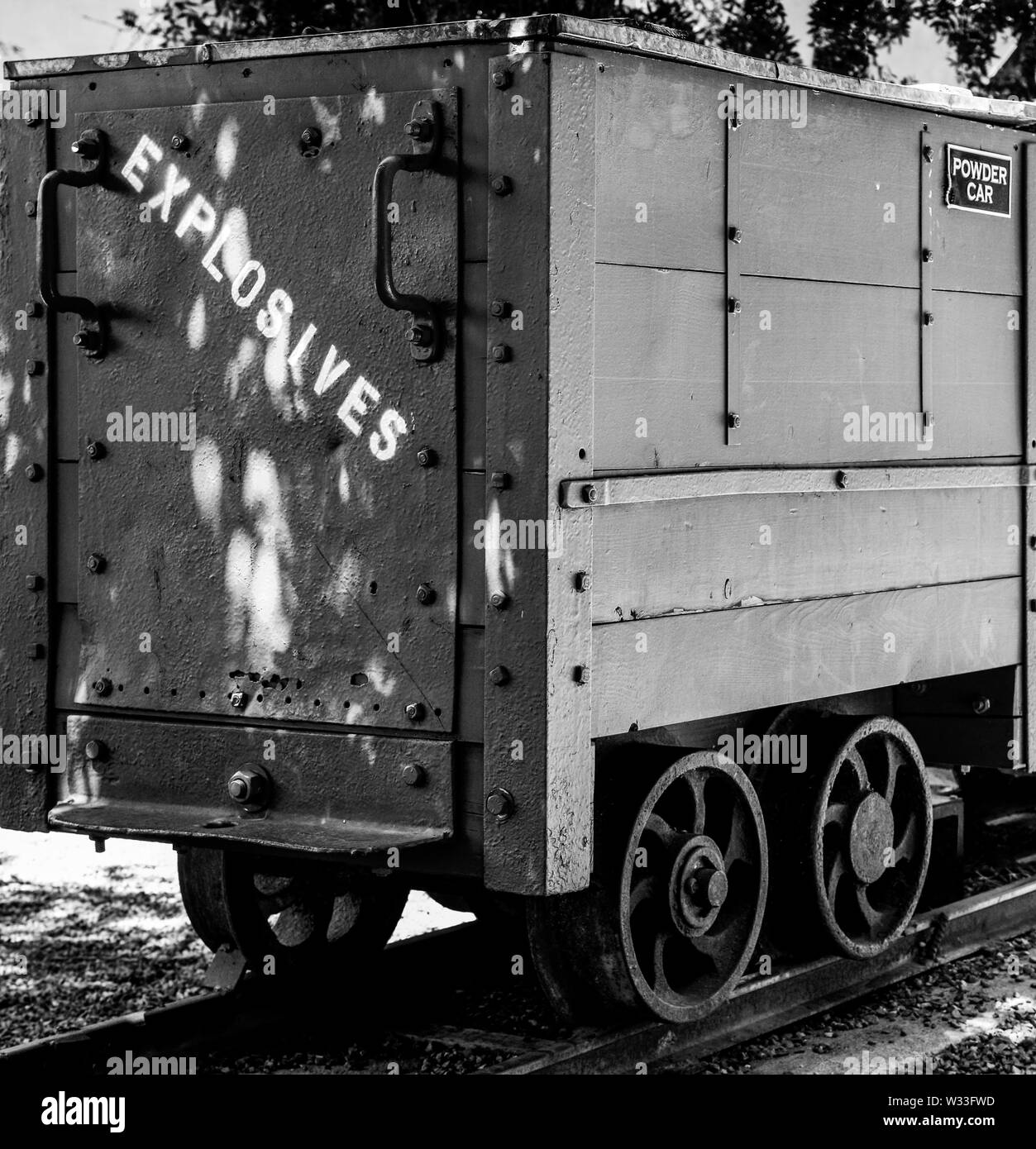 A vintage, rustic, powder car, marked 'Explosives' used in copper mining in small town America, USA, in black and white Stock Photo
