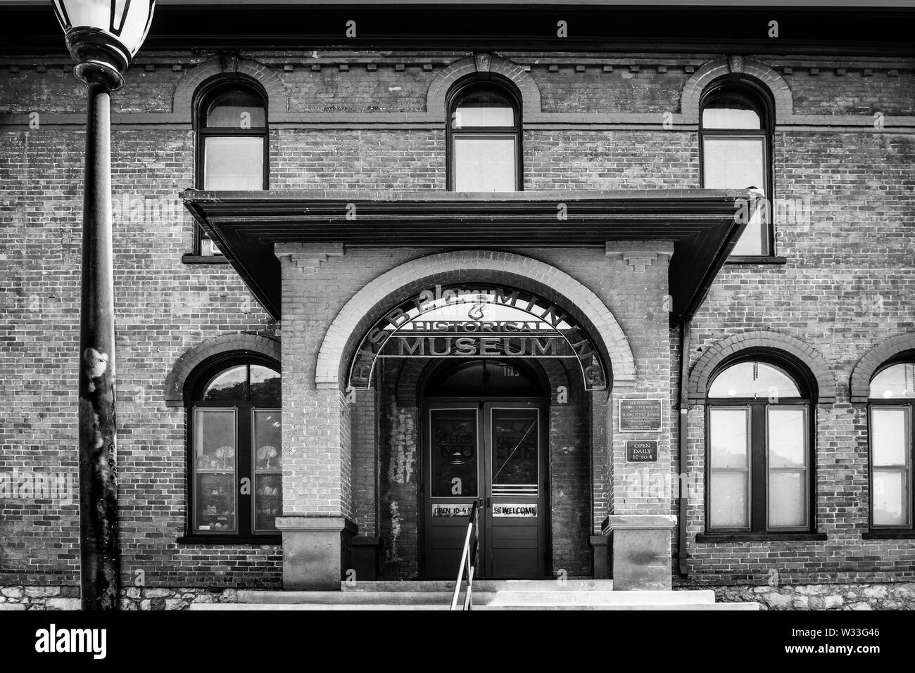 Dramatic black and white view of the. Bisbee Mining and Historical museum front entrance into a vintage brick building, in small town America in Bisbe Stock Photo