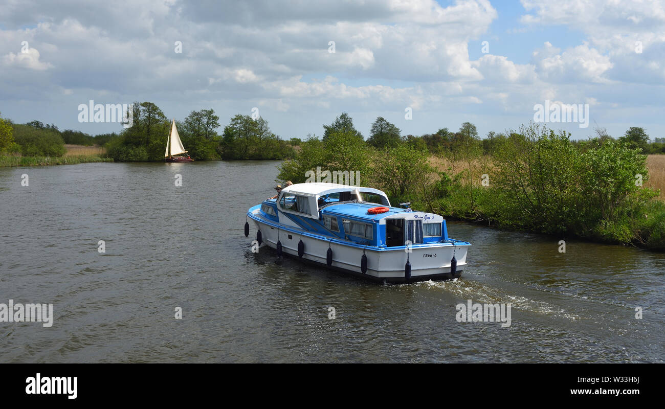 Boards Cruiser and Yacht  under sail navigating  the river Bure   near  Horning, the Norfolk Broads. Stock Photo