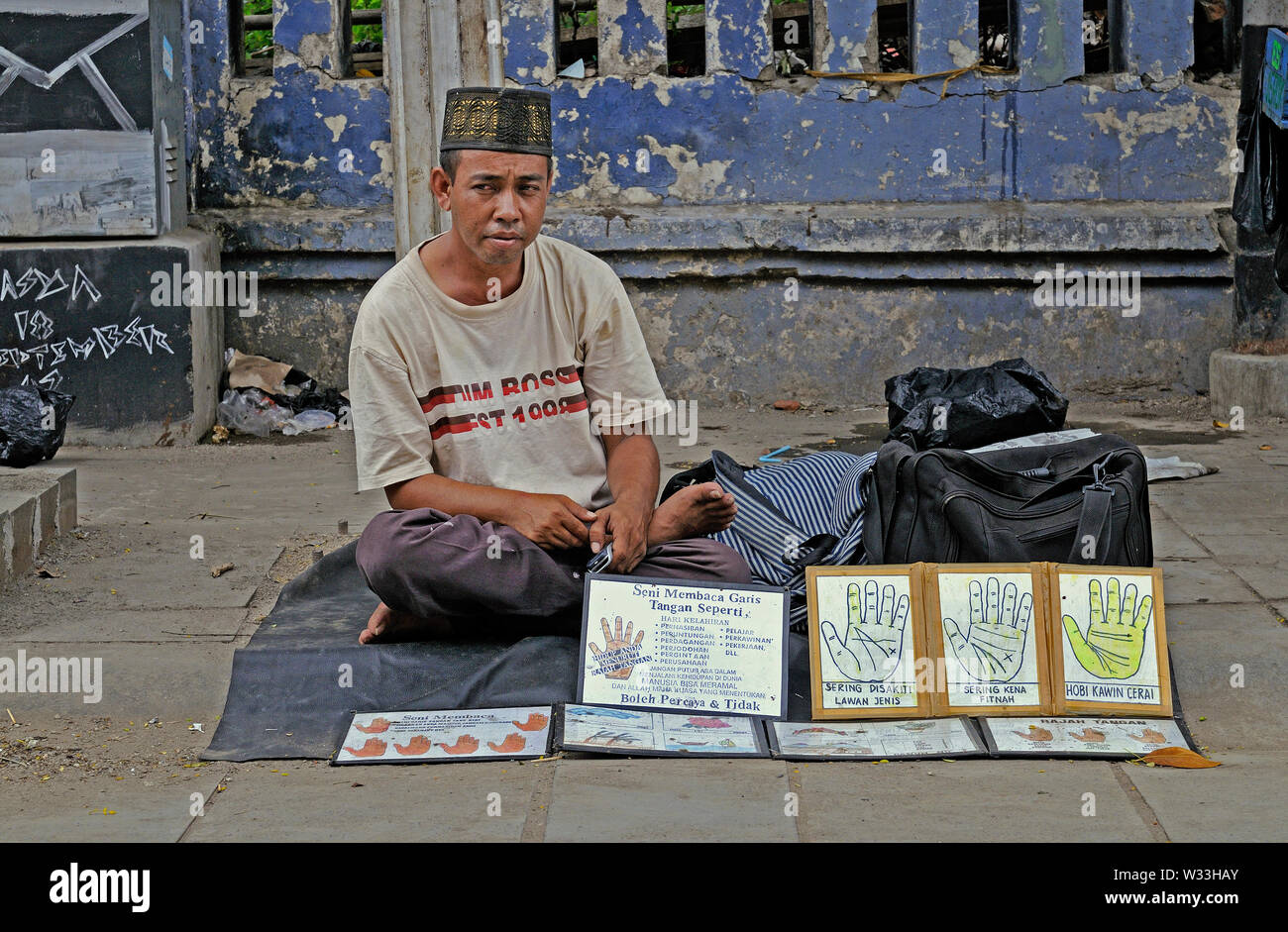 jakarta, dki jakarta / indonesia - may 05, 2010: a palm reader offering his services at the sidewalk of  jalan pintu besar utara in kota old town Stock Photo