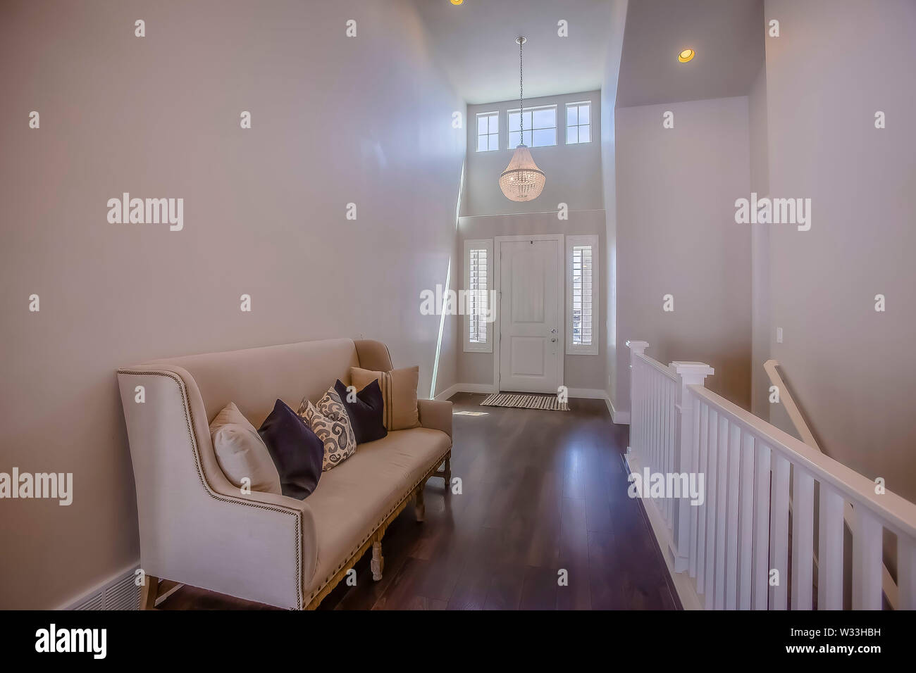 Home Interior With A Sofa In Front Of The Stairs That Leads To The