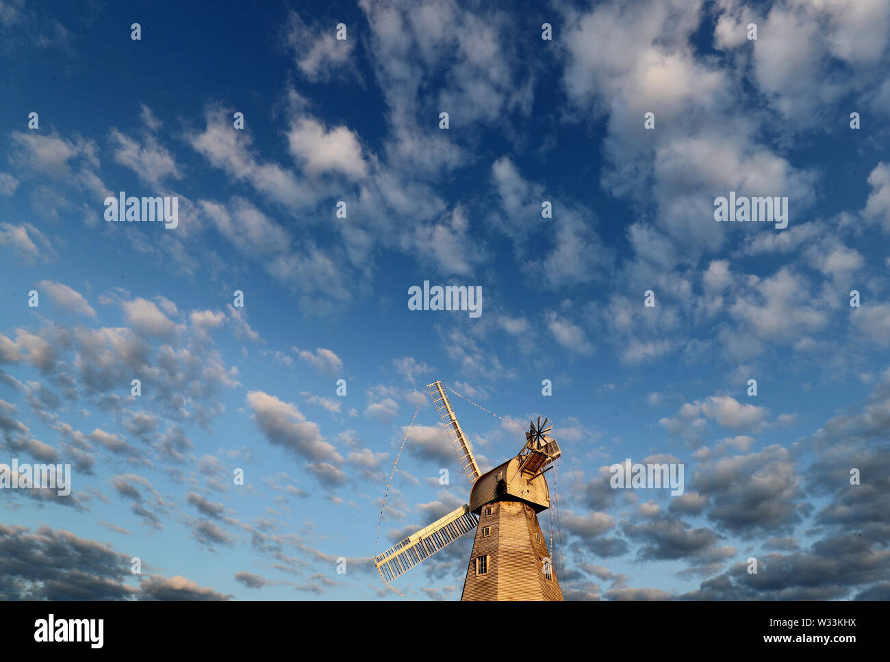 A view of Willesborough Windmill, a restored and working white smock mill built in 1869 in Ashford, Kent, during the morning sunlight. Stock Photo