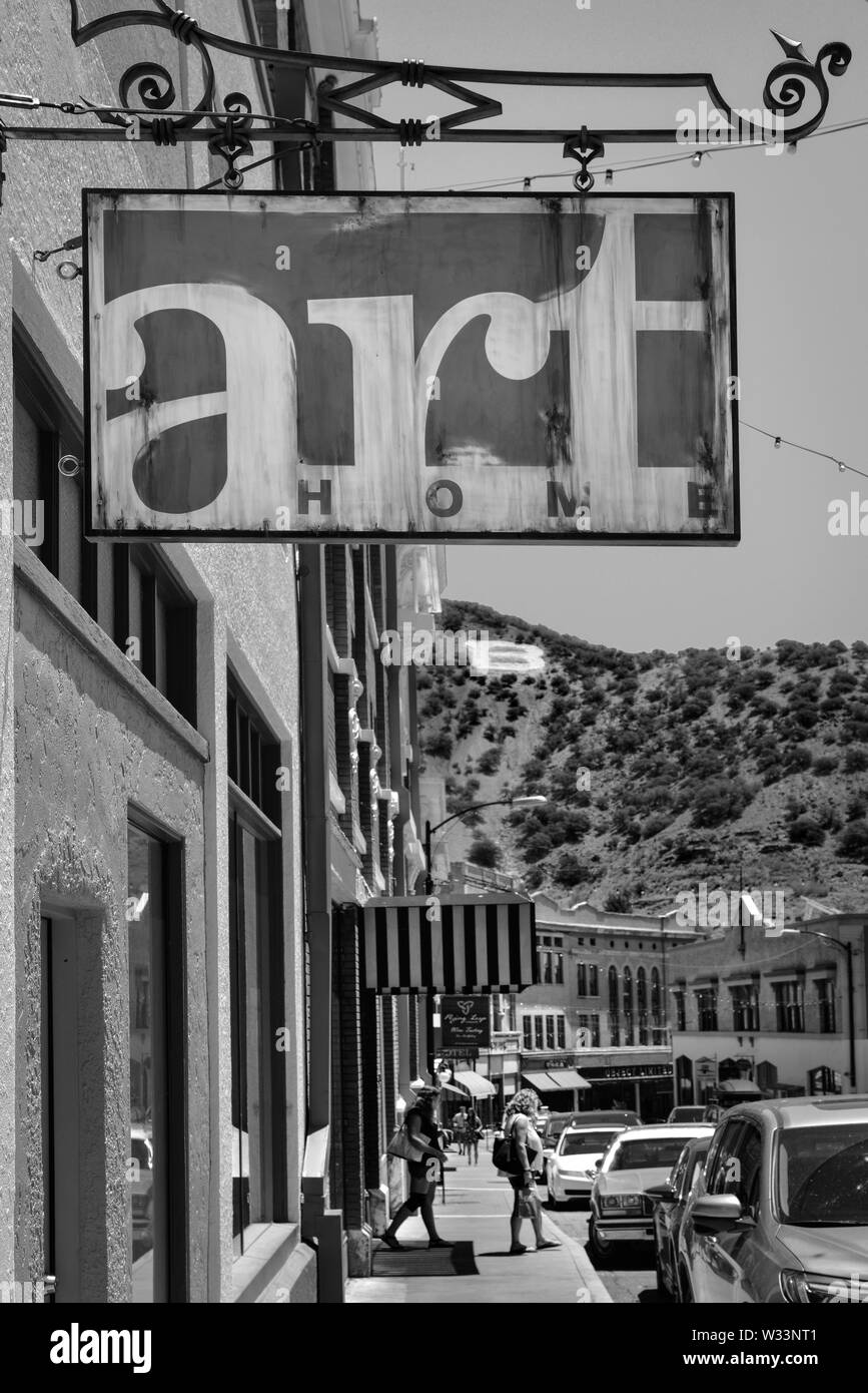 The Art Home store's overhead metal sign frames Main street with shoppers and tourists with the 'B' on Chihuahua hill looking on in the old mining tow Stock Photo