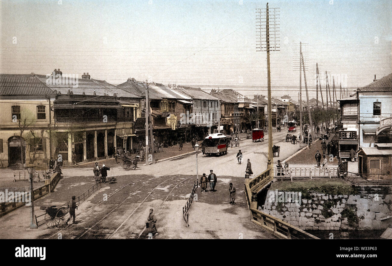 [ 1890s Japan - Shinbashi Bridge at Ginza, Tokyo ] —   A view on the Shinbashi (also Shimbashi) bridge and Ginza avenue in Tokyo, sometime between 1882 (Meiji 15) and 1895 (Meiji 28). The wooden bridge over the Shiodomegawa (Shiodome River) was replaced with an iron bridge in April 1899 (Meiji 32).   This image was published in 1895 (Meiji 28) by Kazumasa Ogawa in Scenes of the Eastern Capital of Japan.  19th century vintage collotype print. Stock Photo