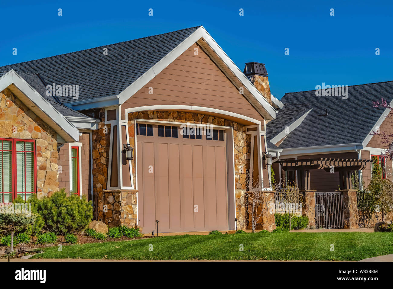 Home with garage door front lawn and metal gate viewed against clear ...