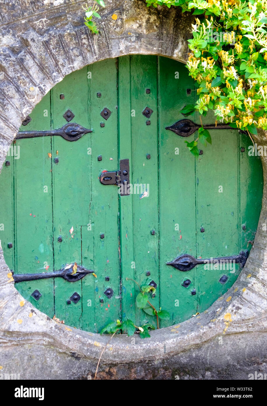The round green door on the garden of Chew cottage, Keynsham  Somerset UK Stock Photo