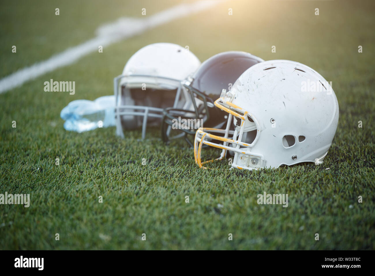 Photo of three football helmets on stadium Stock Photo