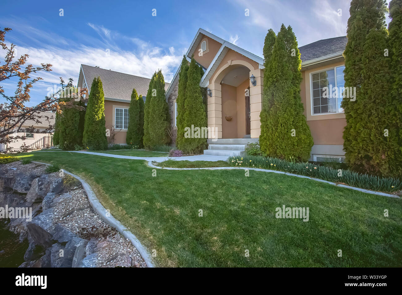 Yard And Conical Shaped Trees At The Facade Of Home Under