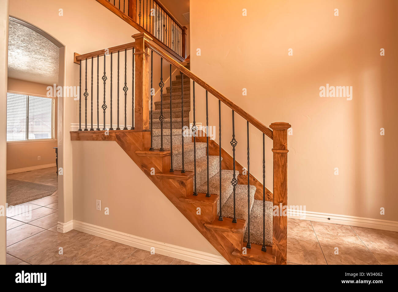 Carpeted Stairs With Wood Handrail And Metal Railing Inside