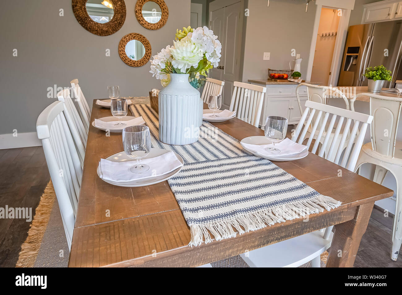 Table Runner Flowers Glasses Napkins And Plates Arranged On Top Of Dining Table White Chairs Wood Floor And An Island Can Also Be Seen Inside This Stock Photo Alamy
